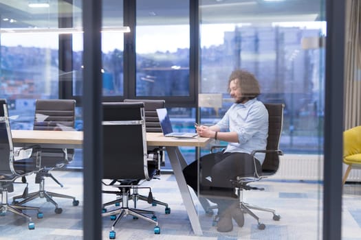 Young casual businessman using smartphone in the startup office