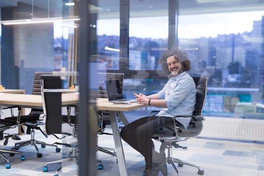 Young casual businessman using smartphone in the startup office