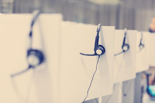 Headphones hanging on cubicle partition in empty call center office