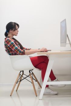 startup business, woman  working on dektop  computer at creative modern office relaxing and have fun