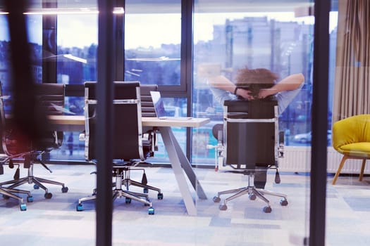 A time for relax. Young tired casual businessman relaxing at the desk in his office