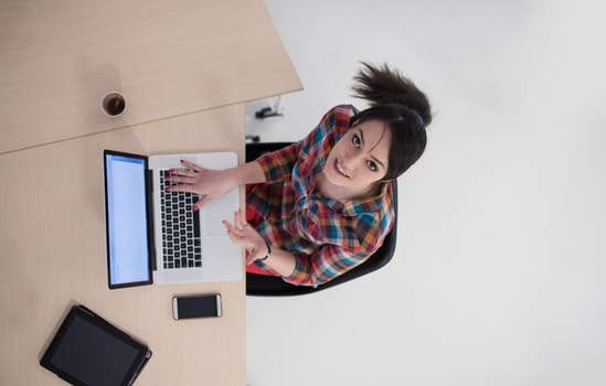 top view of young business woman working on laptop computer in modern bright startup office interior