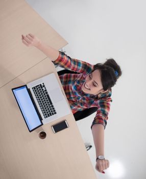 top view of young business woman working on laptop computer in modern bright startup office interior