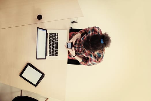 top view of young business woman working on laptop computer in modern bright startup office interior