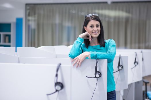 young smiling female call centre operator doing her job with a headset