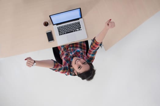 top view of young business woman working on laptop computer in modern bright startup office interior