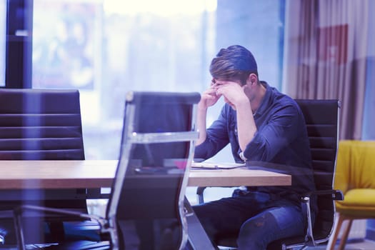 A time for relax. Young tired casual businessman relaxing at the desk in his office