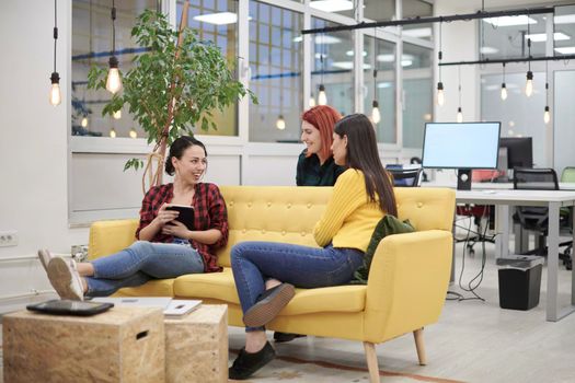 group of female friends having a team meeting and discussion about project or gossip chatting in modern startup business office