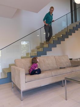 Portrait of cute little girl playing games on smartphone at home