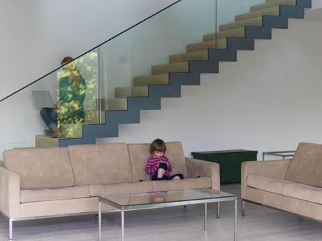 Portrait of cute little girl playing games on smartphone at home