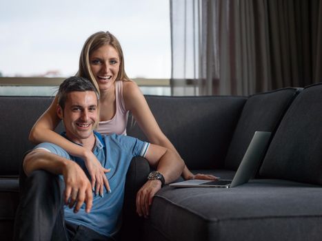 Attractive couple using a laptop in the living room