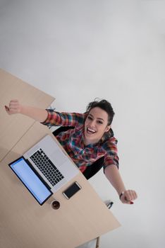 top view of young business woman working on laptop computer in modern bright startup office interior