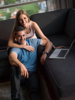 Attractive couple using a laptop in the living room