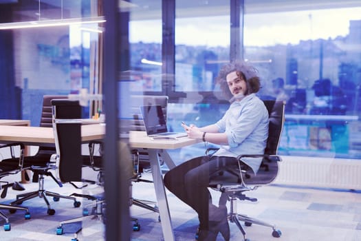 Young casual businessman using smartphone in the startup office