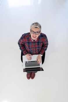 top view of young business woman working on laptop computer in modern bright startup office interior, sitting on floor