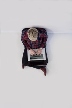 top view of young business woman working on laptop computer in modern bright startup office interior, sitting on floor