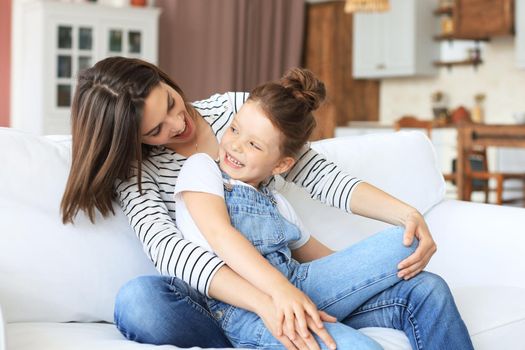 Happy loving mom hugging little daughter, spend time together at home