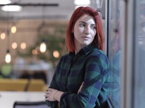 redhead business woman portrait as influencer in creative modern coworking startup open space office