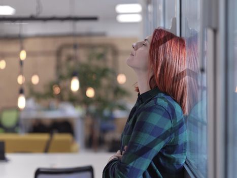 redhead business woman portrait as influencer in creative modern coworking startup open space office