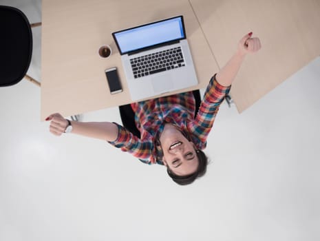 top view of young business woman working on laptop computer in modern bright startup office interior