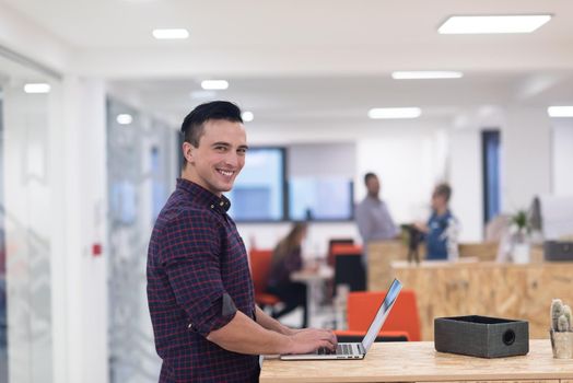 portrait of young businessman in casual clothes at modern  startup business office space,  working on laptop  computer