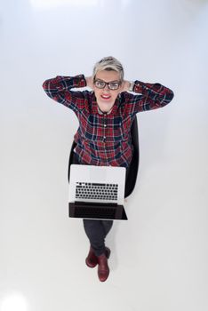 top view of young business woman working on laptop computer in modern bright startup office interior, sitting on floor