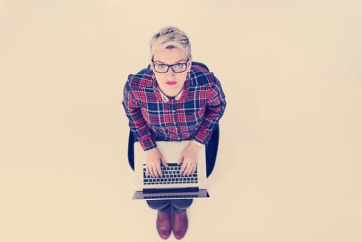 top view of young business woman working on laptop computer in modern bright startup office interior, sitting on floor