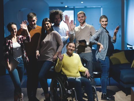 Disabled businesswoman in a wheelchair at the office with coworkers. Portrait of a diverse business team in a modern open space coworking office space. High quality photo