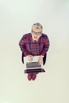 top view of young business woman working on laptop computer in modern bright startup office interior, sitting on floor