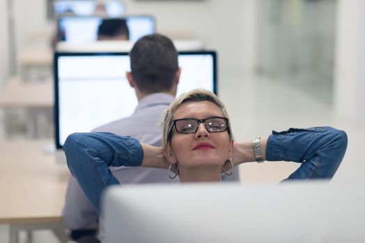 startup business, woman  working on dektop  computer at creative modern office relaxing and have fun