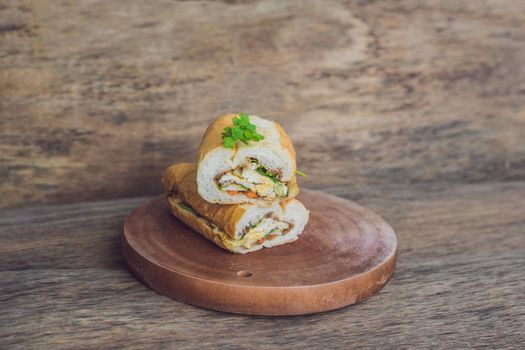 A delicious Vietnamese Bahn Mi sandwich on a wooden background.