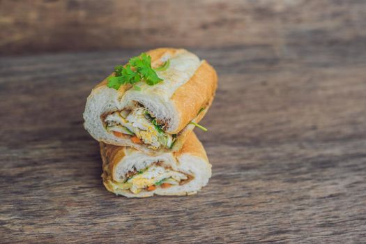 A delicious Vietnamese Bahn Mi sandwich on a wooden background.