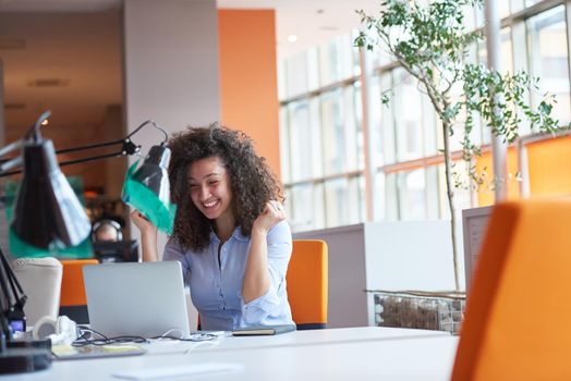 happy young  business woman with curly hairstyle in the modern office