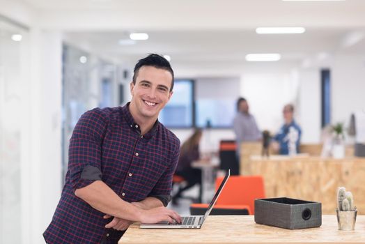 portrait of young businessman in casual clothes at modern  startup business office space,  working on laptop  computer