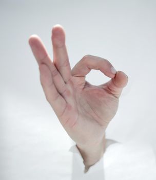 close up.male hand breaking through the paper wall and showing OK .photo with copy space