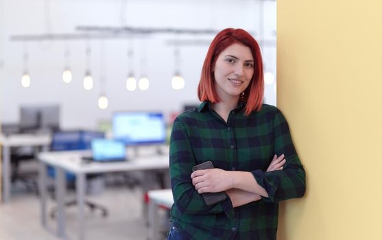 redhead business woman portrait as influencer in creative modern coworking startup open space office