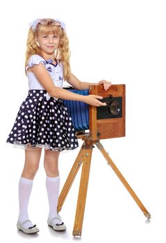 Beautiful little blonde girl near the large, wooden, vintage camera-Isolated on white background