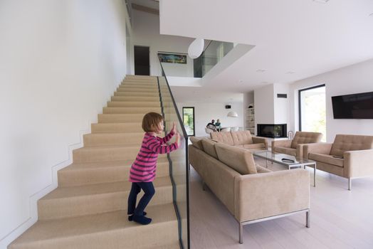 happy young family with little girl enjoys in the modern living room of their luxury home villa