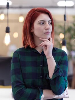 redhead business woman portrait as influencer in creative modern coworking startup open space office