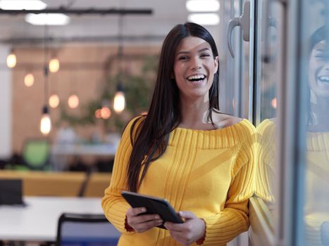 business woman portrait  in open space startup coworking office as influencer  using smart phone, tablet computer