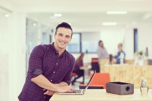 portrait of young businessman in casual clothes at modern  startup business office space,  working on laptop  computer