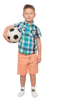 Beautiful little boy with a fashionable hairstyle on the head . The boy is holding under one arm a football . Portrait in full growth - Isolated on white background