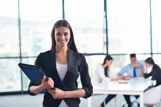 happy young business woman  with her staff,  people group in background at modern bright office indoors