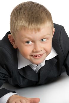 Cute little boy in a suit and white shirt. Lying on the floor and smiles. close-up - Isolated on white background