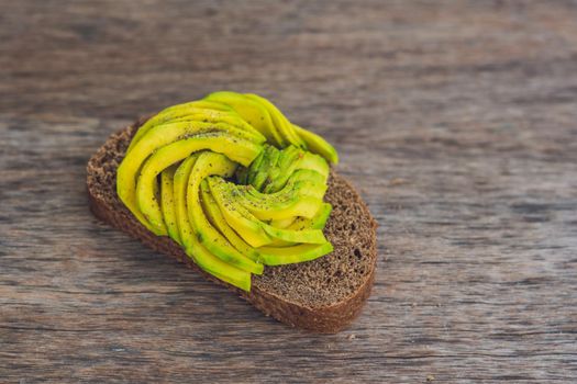 Avocado sandwich on dark rye bread made with fresh sliced avocados.