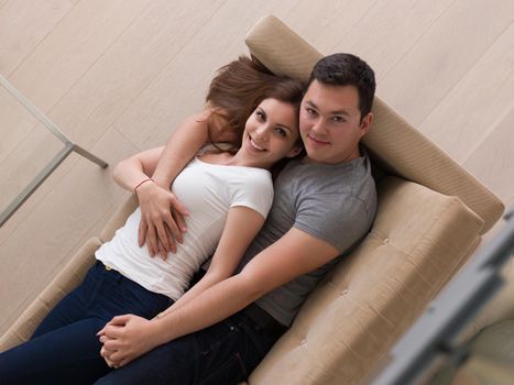 young handsome couple enjoys hugging on the sofa in their luxury home villa