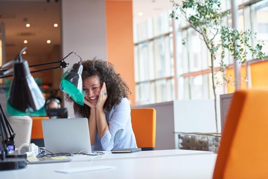 happy young  business woman with curly hairstyle in the modern office