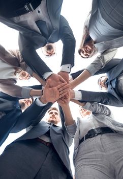 bottom view. business team showing unity with their hands together.the concept of teamwork