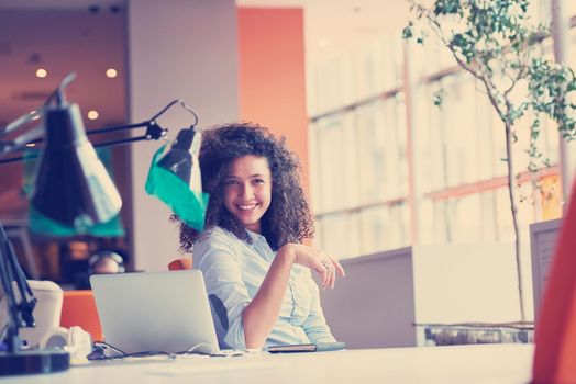 happy young  business woman with curly hairstyle in the modern office