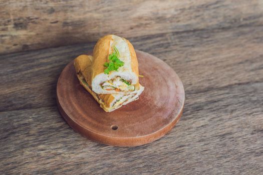 A delicious Vietnamese Bahn Mi sandwich on a wooden background.